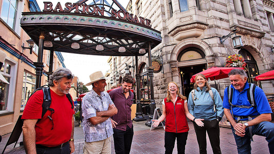 Group of people standing in front of a building with 'Bastion Square' sign.