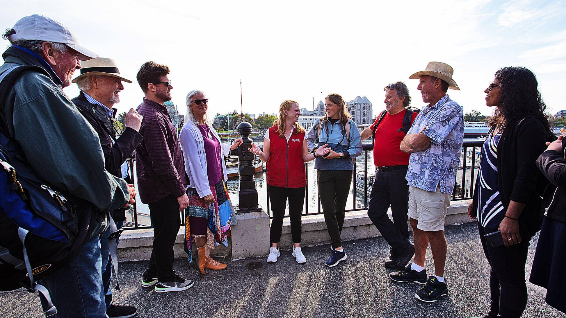 Group of people standing on a bridge with a cityscape in the background